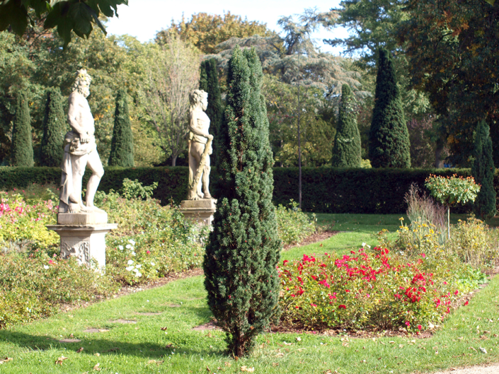 Zwei Skulpturen stehen in einem Park.