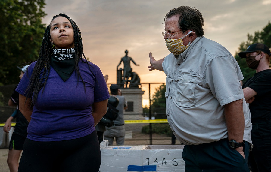 Eine Frau und ein Mann diskutieren vor einem Denkmal.