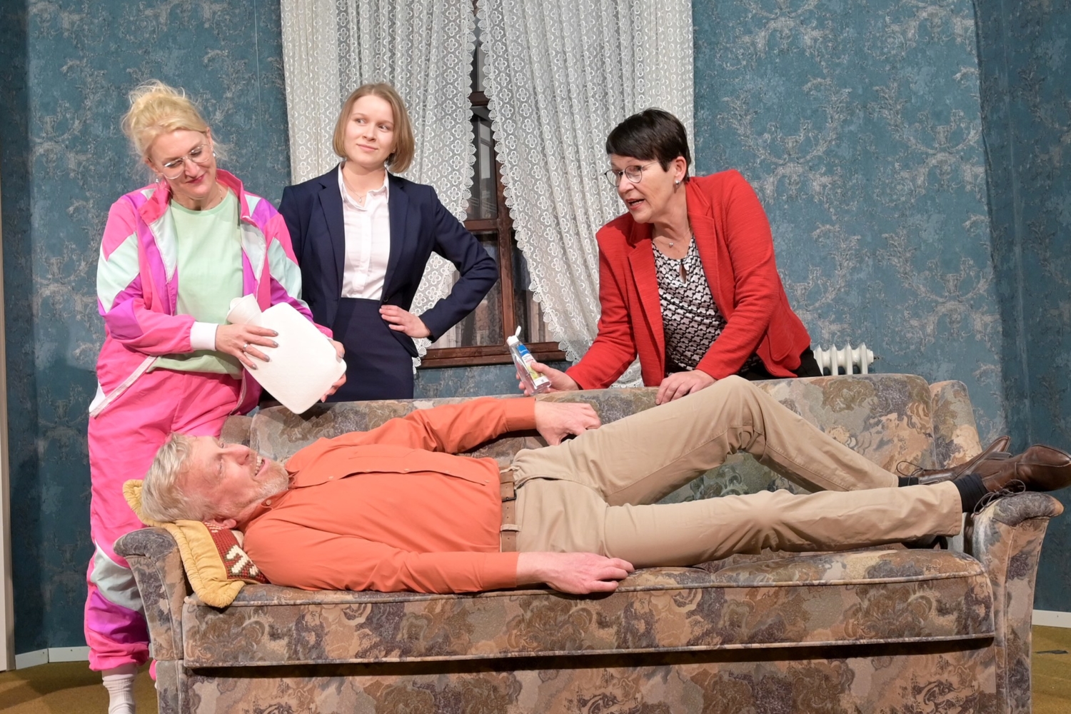Valentin Müller (Jörg Neddermann) liegt auf dem alten Sofa. Um ihn kümmern sich (v.l.) Frau Boisen (Corinna Bär), Sophie Stratmann (Lina Clausen) und Marie Stratmann (Marika Schrader).