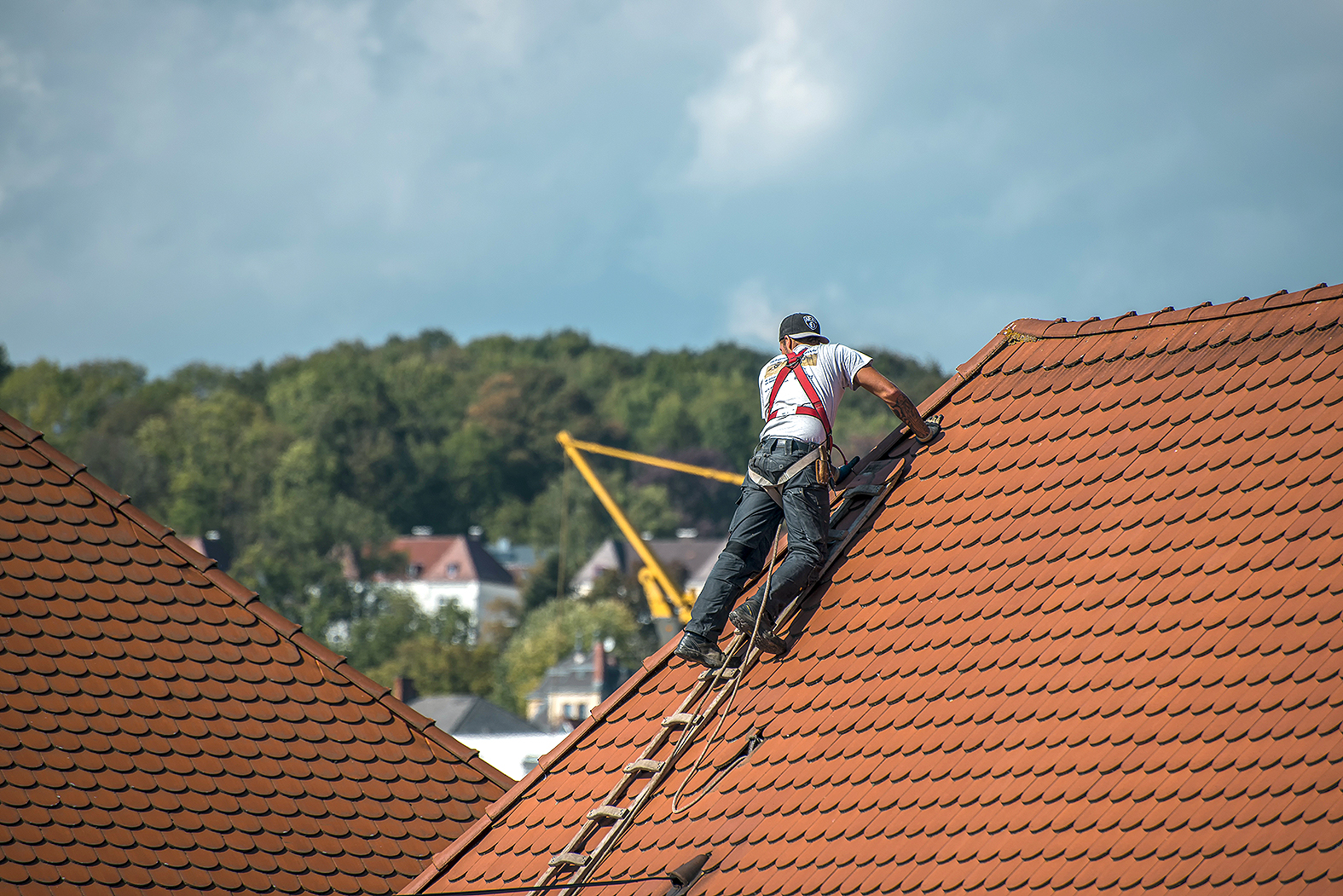 Ein Dachdecker bei der Arbeit auf einem Dach.