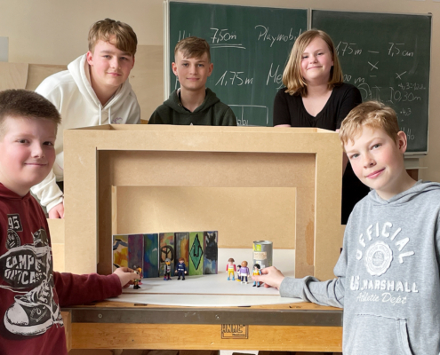 Während der Projektwoche bauten Schüler ein Modell der Bühne des Metropoltheaters Bremen nach. Der Nachbau aus Holz entspricht dem Maßstab der Spielfiguren. Eine mögliche Szene vor der Berliner Mauer bauen auf: Jarik (v.l.), René, Jannis, Sara und Marlon.