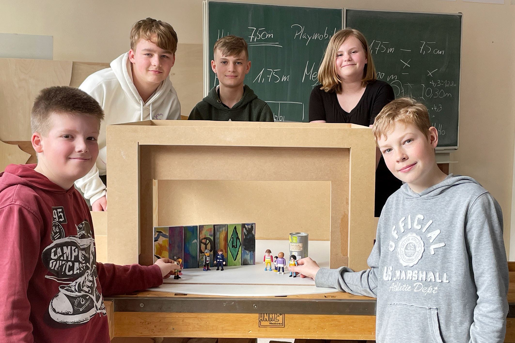 Während der Projektwoche bauten Schüler ein Modell der Bühne des Metropoltheaters Bremen nach. Der Nachbau aus Holz entspricht dem Maßstab der Spielfiguren. Eine mögliche Szene vor der Berliner Mauer bauen auf: Jarik (v.l.), René, Jannis, Sara und Marlon.